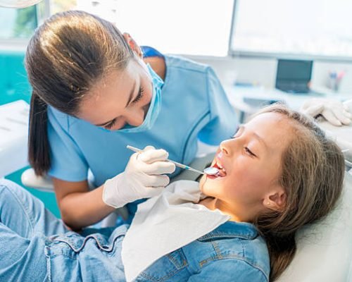 Beautiful girl at the dentist getting a check up on her teeth - pediatrics dental care concepts